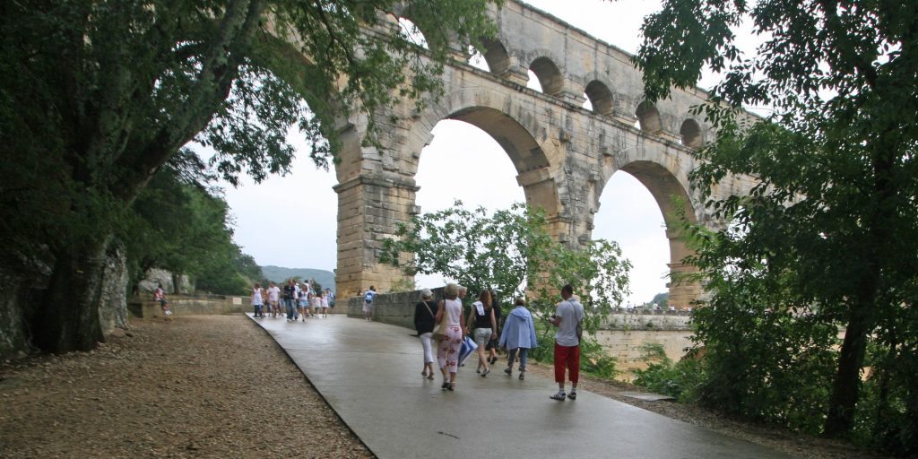 Pont du Gard in France with visiting pedestrians and cyclists enjoying the historic Roman aqueduct.